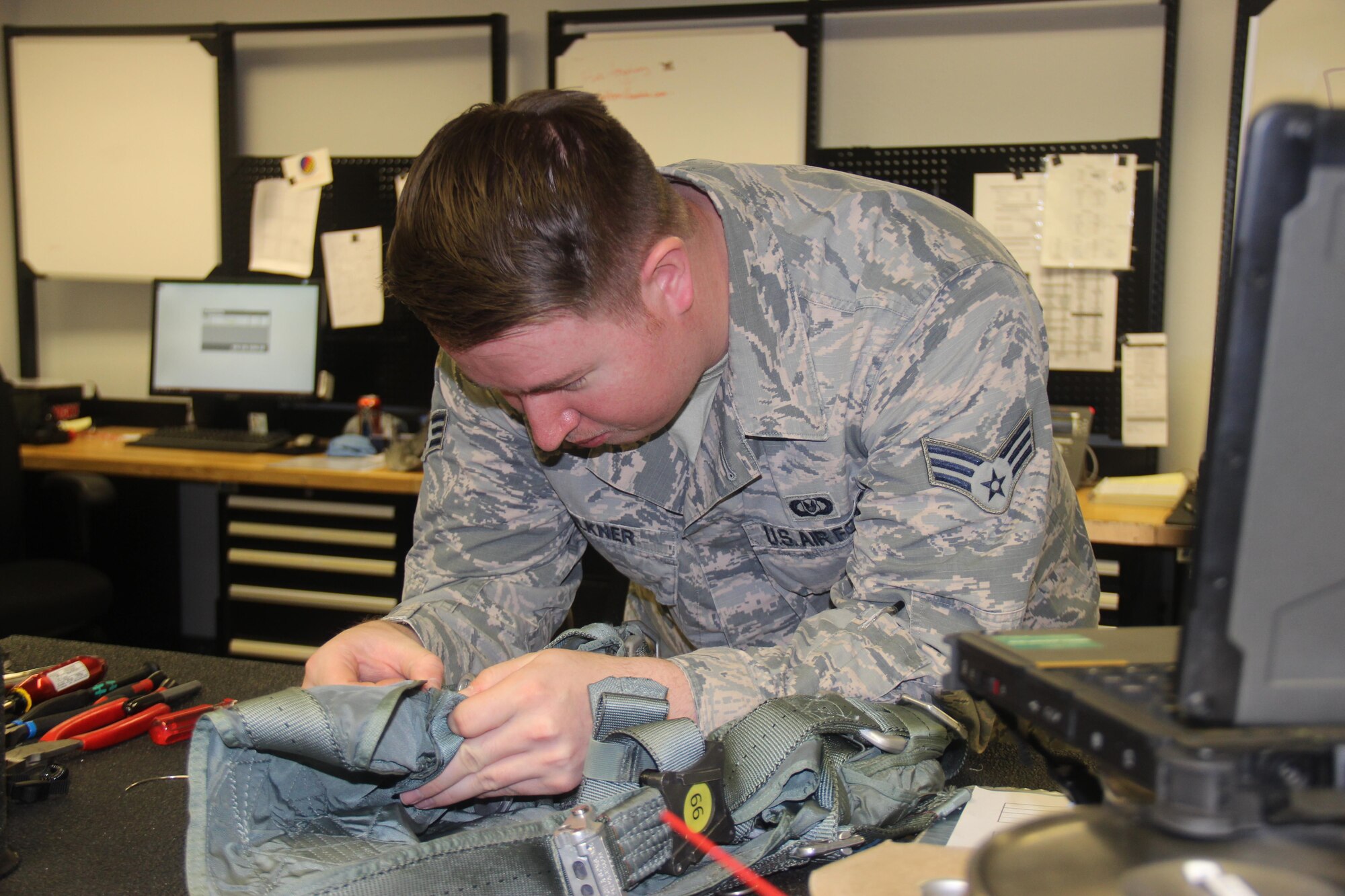 Senior Airman Aaron Faulkner, 57th Weapons Support Squadron aircrew flight equipment journeyman, works on an F-15 and A-10 pilot’s harness at Nellis Air Force Base, Nev., June 13, 2016. The 57 WPSS AFE section maintains life-preserving equipment for multiple airframes, ensuring crew members return home safely. (U.S. Air Force photo by Susan Garcia)

