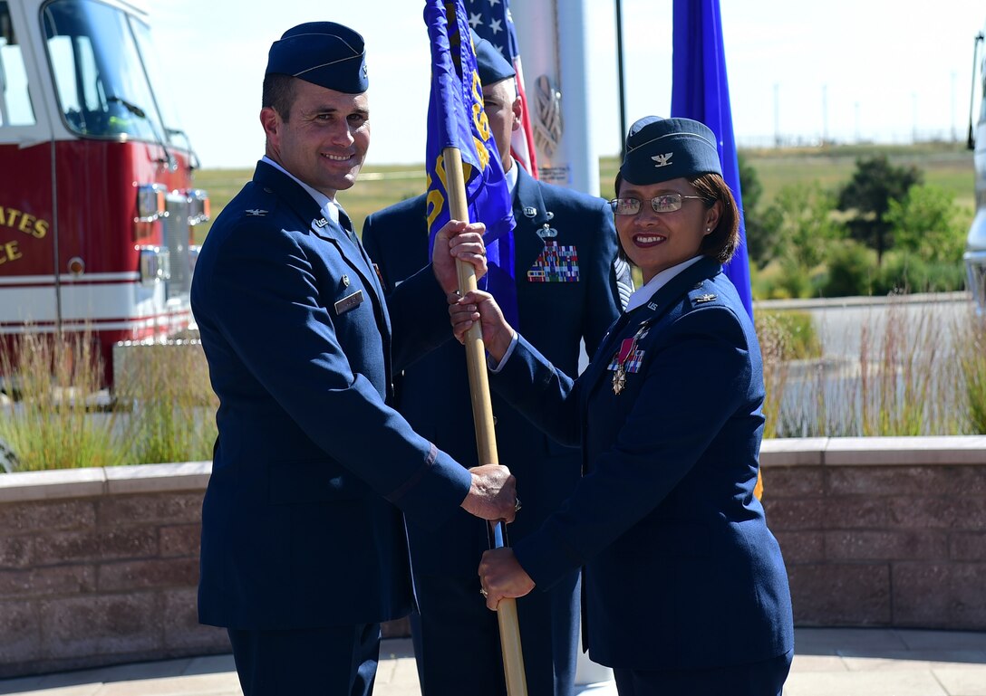 Col. Rose Jourdan, former 460th Mission Support Group commander, relinquishes the MSG guide-on to Col. John Wagner, 460th Space Wing commander, August 1, 2016, during the MSG change of command on Buckley Air Force Base, Colo. The outgoing commander passes the guide-on to the incoming commander to symbolize that the group will never be without a leader. (U.S. Air Force photo by Airman 1st Class Gabrielle Spradling/Released)