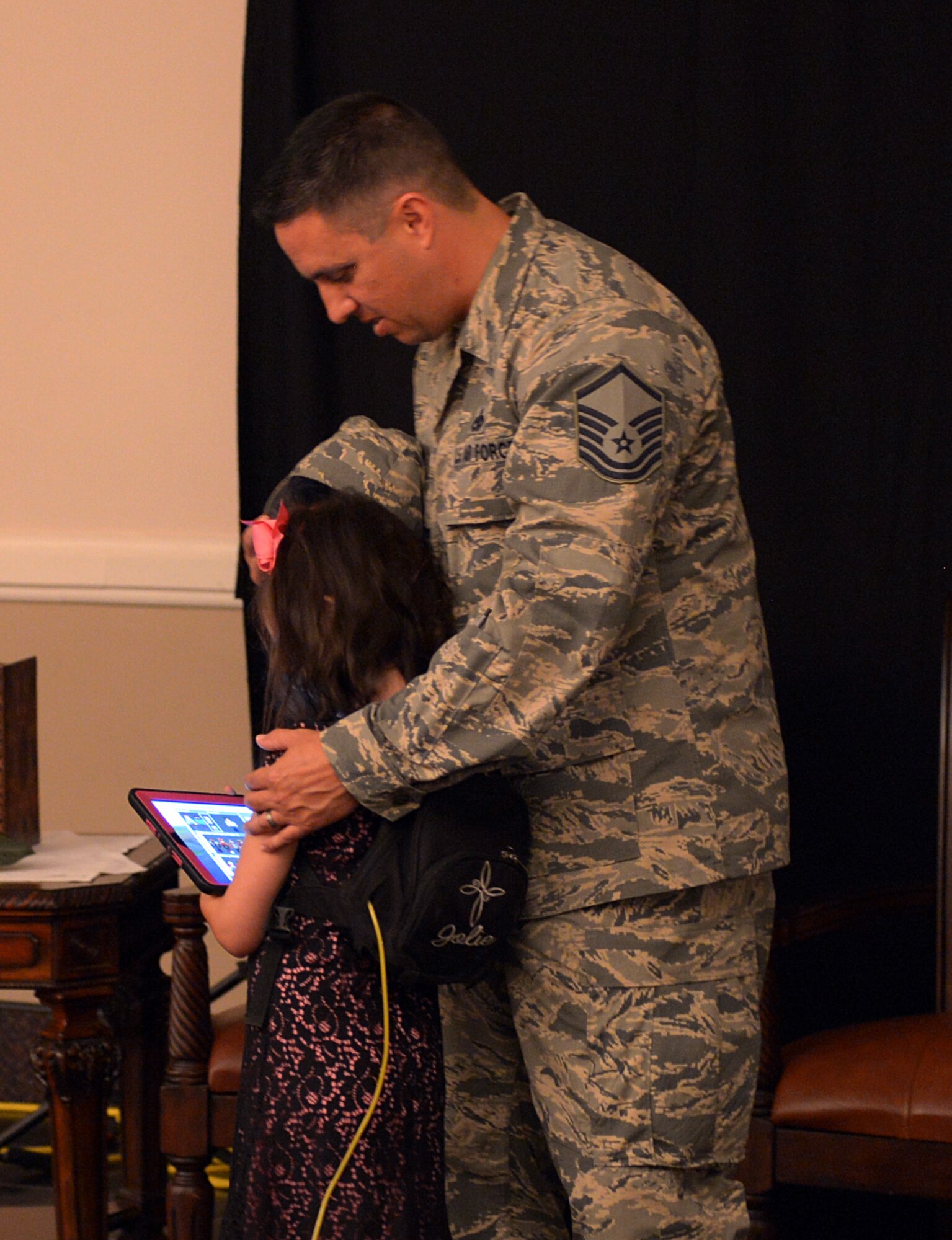 Master Sgt. Jerami Reyna, 2nd Maintenance Squadron flight inspection section chief, embraces his daughter during a Storytellers event at Barksdale Air Force Base, La., July 26, 2016. Reyna’s daughter is just the 12th reported case in the world of people diagnosed with Mitochondrial disease, an extremely rare disease, characterized by failures of the mitochondria responsible for producing over 90% of the energy the body needs to sustain life. (U.S. Air Force photo/Senior Airman Curt Beach)