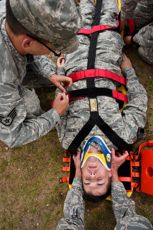 Staff Sgt. Corey Czajka, 21st Aerospace Medicine Squadron independent duty medical technician, straps a mock patient with a possible critical spine injury to a long backboard during a training exercise at Peterson Air Force Base, Colo., July 28, 2016. Czajka used these same skills to stabilize a woman in a vehicle accident a few weeks prior when the vehicle was broadsided and rolled over. (U.S. Air Force photo by Senior Airman Rose Gudex)