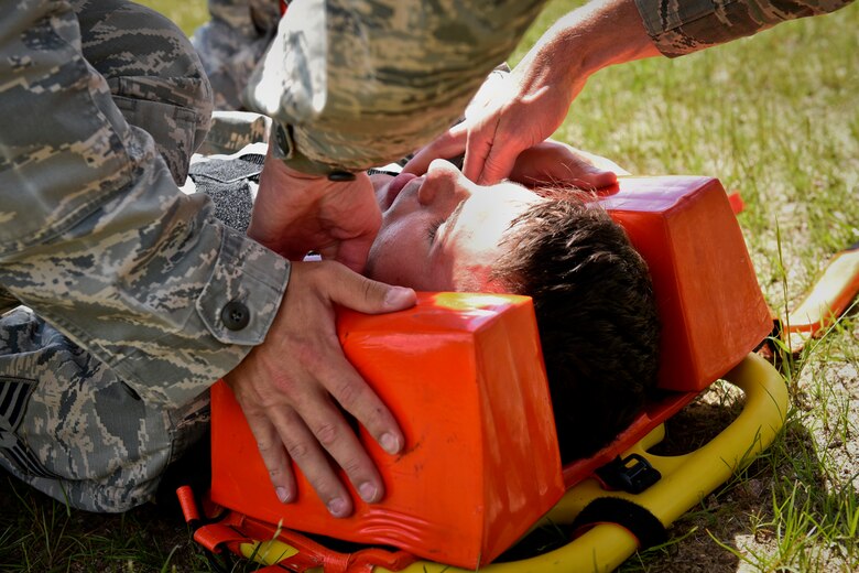 21st Aerospace Medicine Squadron independent duty medical technicians place head blocks next to a mock patient’s head to stabilize it in case of any critical spine injury during a training exercise at Peterson Air Force Base, Colo., July 28, 2016. The mission of an IDMT is to provide traditional medical care like diagnosing, treating and prescribing, but also conduct the same duties alone while in the field and with limited resources. (U.S. Air Force photo by Senior Airman Rose Gudex)