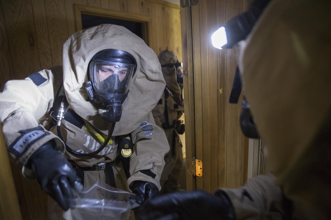 Lance Cpl. Joshua J. Bracken, a chemical, biological, radiological and nuclear defense specialist with 4th Combat Engineer Battalion, 4th Marine Division, Marine Forces Reserve, prepares to receive a chemical sample at the site of a simulated chemical warfare lab in an abandoned hotel at Pilottown, La., July 29, 2016. The training event was part of a hazardous material technician training course held by MARFORRES. (U.S. Marine Corps photo by Sgt. Ian Leones/ Released)