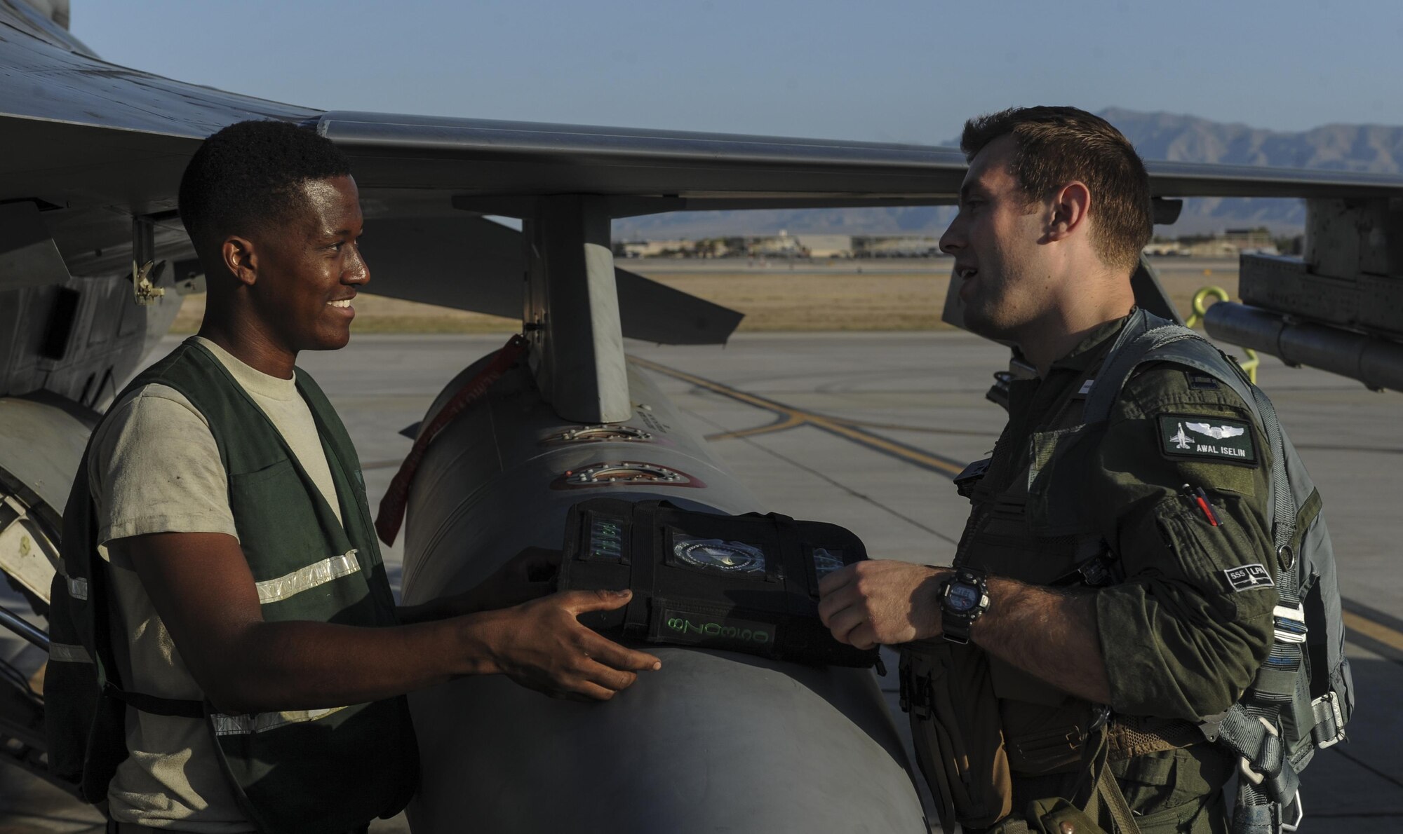 Senior Airman Dominique Patton, 555th Fighter Squadron, Aviano Air Force Base, Italy, crew chief, and Capt Awal Iselin, 555th FS pilot, review a pre-flight binder before take-off at Nellis Air Force Base, Nev., August 2, 2016. The 555th FS is participating with other branches and allies in a large scale air-to-ground excercise at Fort Irwin, Ca. known as Green Flag 16-8. (United States Air Force photo by Airman 1st Class Kevin Tanenbaum/Released)