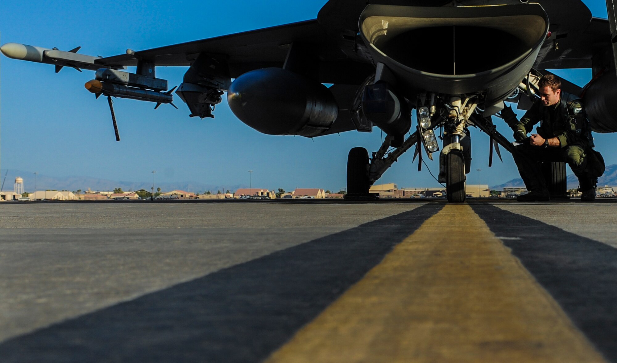 Capt. Awal Iselin, 555th Fighter Squadron, Aviano Air Force Base, Italy, pilot, performs a walk around of an F-16 Fighting Falcon at Nellis Air Force Base, Nev., August 2, 2016, before it participation in Green Flag 16-8. On average, all four military services, including the guard and reserve components, participate in two Green Flag exercises each year. (United States Air Force photo by Airman 1st Class Kevin Tanenbaum/Released)