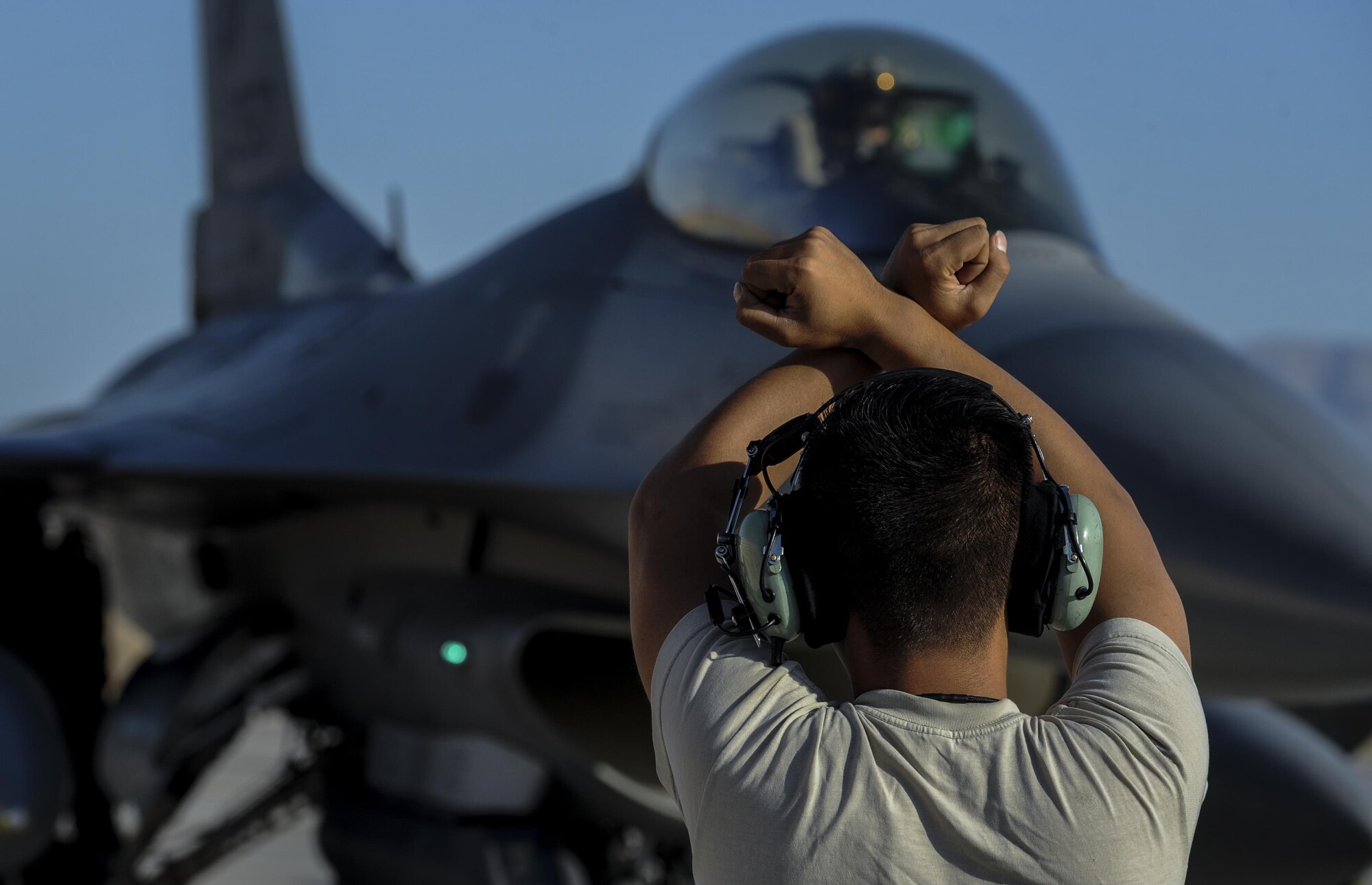 Staff Sgt. Sonethasinh Sayaseng, 31st Aircraft Maintenance Squadron, Aviano Air Force Base, Italy, avionics journeyman, marshals an F-16 for take-off at Nellis Air Force Base, Nev., August 2, 2016, to participate in Green Flag 16-8. A typical Green Flag exercise involves two multi-role fighter and/or bomber squadrons, unmanned aircraft, electronic warfare aircraft, and aerial refueling aircraft. (United States Air Force photo by Airman 1st Class Kevin Tanenbaum/Released)