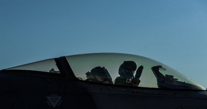 Capt. Awal Iselin, 555th Fighter Squadron, Aviano Air Force Base, Italy, pilot, salutes as he taxis before take-off at Nellis Air Force Base, Nev., Aug. 2, 2016. The 555th FS is participating in Green Flag 16-8, a large scale air-to-ground combat exercise. (United States Air Force photo by Airman 1st Class Kevin Tanenbaum/Released)