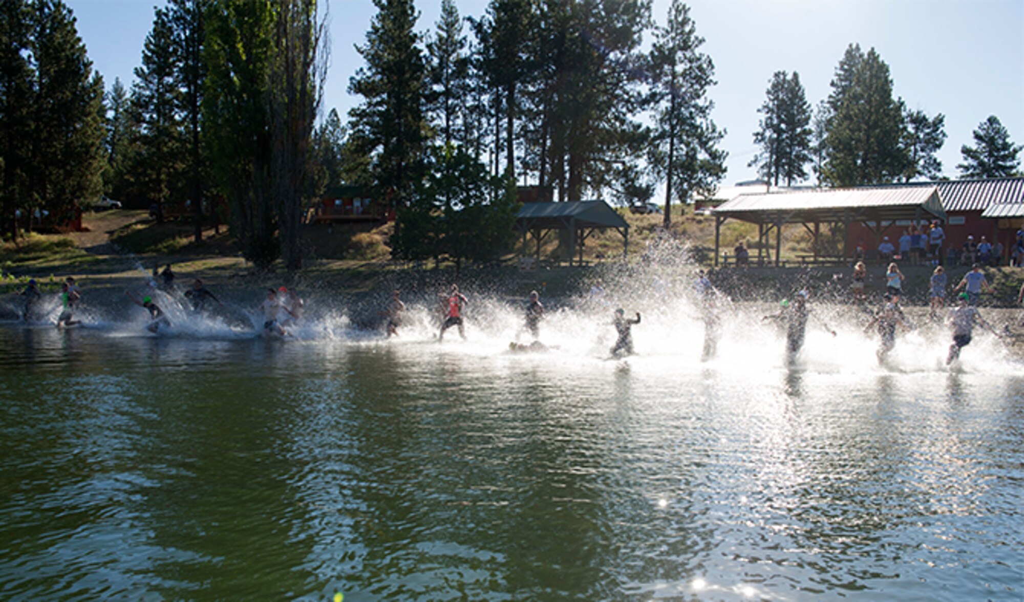 Members of Team Fairchild plunge into the water during the  swim portion of the Clear Lake Triathlon July 30, 2016, at Medical Lake, Wash. The course consisted of a 500 meter swim, 17.5 kilometer bike ride and a five kilometer run. (U.S. Air Force photo/Airman 1st Class Sean Campbell)