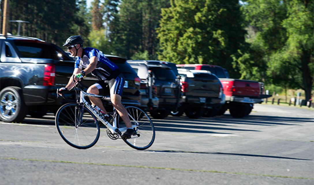 Lt. Col. Daniel Rigsbee, 92nd Force Support Squadron commander, participates in the cycling portion of the Clear Lake Triathlon July 30, 2016, at Medical Lake, Wash. Rigsbee was part of the 92nd FSS team, the Force, which came in first place for teams. (U.S. Air Force photo/Airman 1st Class Sean Campbell)