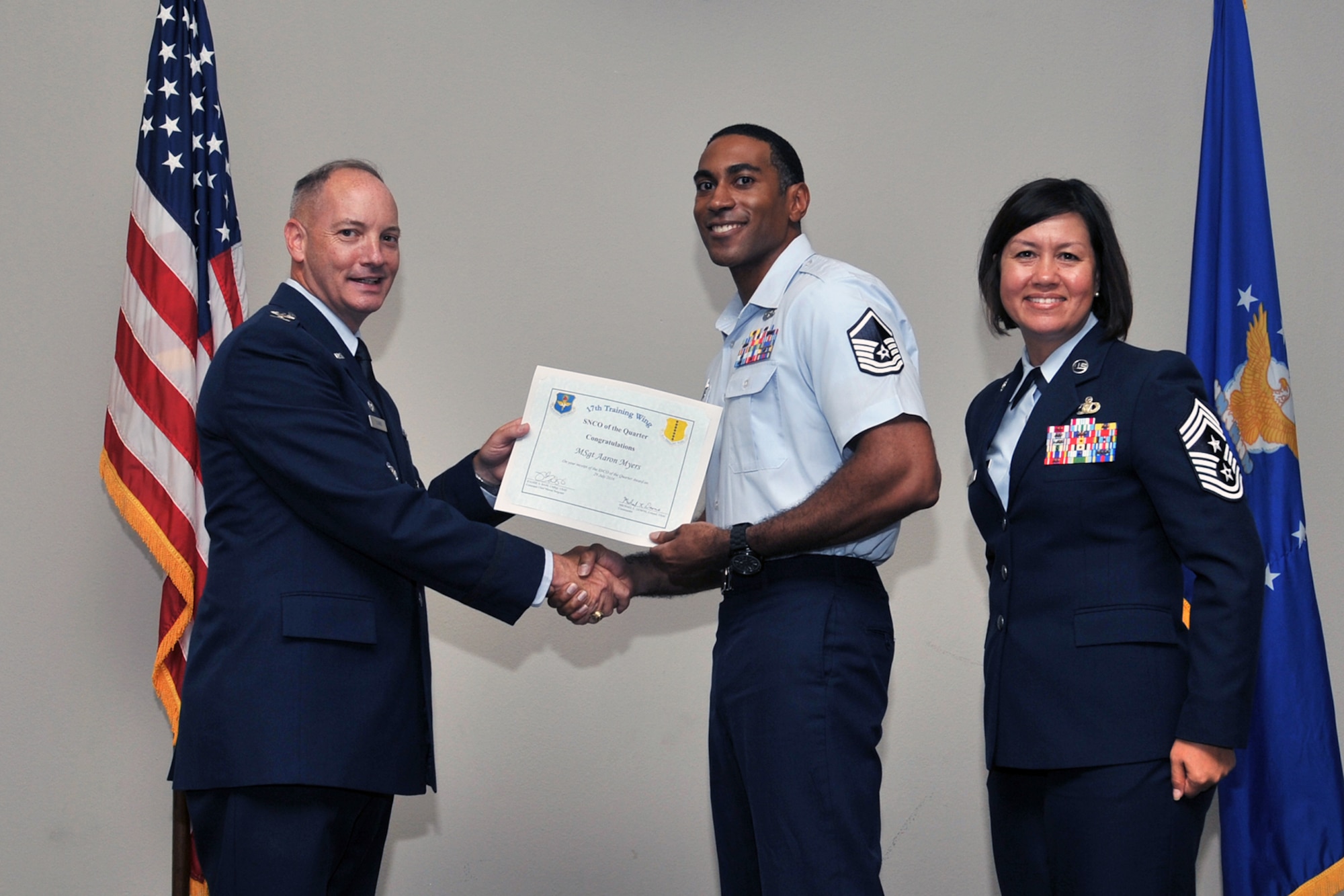 U.S. Air Force Col. Michael Downs, 17th Training Wing Commander, and Chief Master Sgt. JoAnne Bass, 17th Training Wing Command Chief, present the 17th Training Wing Senior NCO of the Quarter award to Master Sgt. Aaron Myers, 17th Communications Squadron, during the wing quarterly awards ceremony at the Event Center on Goodfellow Air Force Base, Texas, July 29, 2016. (U.S. Air Force photo by Staff Sgt. Laura R. McFarlane/Released)