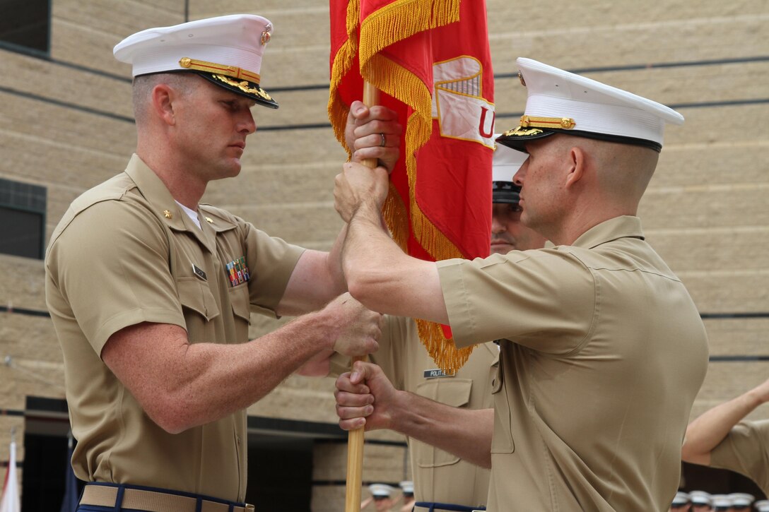 Major James P. Dollard (right), outgoing commanding officer of Recruiting Station Orange County, Calif., hands the Marine Corps colors to Maj. Michael “Adam” Taylor during the change of command ceremony, July 1, 2016. Taylor is coming from Air Force Command and Staff College in Montgomery, Ala. and Dollard is heading to the Command and Staff College aboard Marine Corps Base Quantico, Virginia.(U.S. Marine Corps photo by Sgt. Vanessa Jimenez)