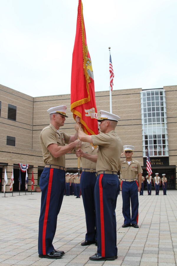 Major James P. Dollard (right), outgoing commanding officer of Recruiting Station Orange County, Calif., hands the Marine Corps colors to Maj. Michael “Adam” Taylor during the change of command ceremony, July 1, 2016. Taylor is coming from Air Force Command and Staff College in Montgomery, Ala. and Dollard is heading to the Command and Staff College aboard Marine Corps Base Quantico, Virginia.(U.S. Marine Corps photo by Sgt. Vanessa Jimenez)