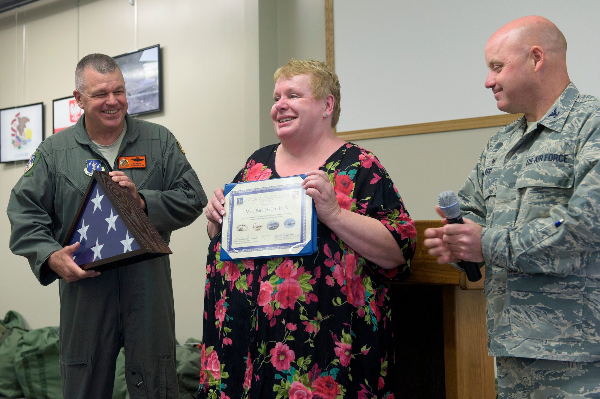 Patricia Tetidrick, an administrative support technician with the 182nd Logistics Readiness Squadron, Illinois Air National Guard, receives accolades from 182nd Airlift Wing Commander Col. William Robertson, left, and 182nd Mission Support Group Commander Col. Cory Reid at a luncheon held in her honor in Peoria, Ill., July 28, 2016. Tetidrick retired Aug. 1 after 41 years, five months and 21 days of service as a Title 5 federal technician. (U.S. Air National Guard photo by Staff Sgt. Lealan Buehrer)