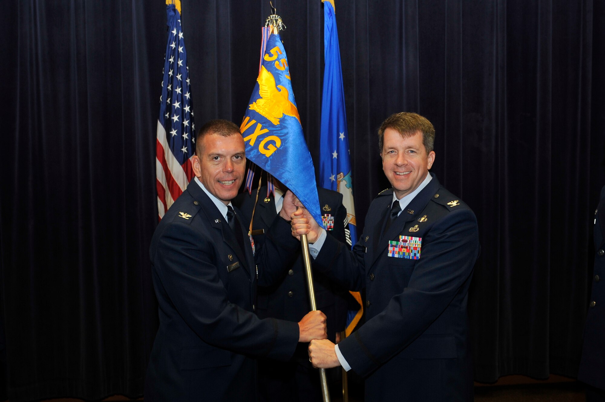 Col. Steven Dickerson, commander of the 557th Weather Wing, left, receives the guidon from Col. Steven Shannon, the outgoing commander of the 2nd Weather Group in the 557th WW Auditorium at Offutt Air Force Base, Neb., Aug. 1, 2016. Shannon passed command to Col. Jason Patla. (U.S. Air Force photo/Jeff Bridges)