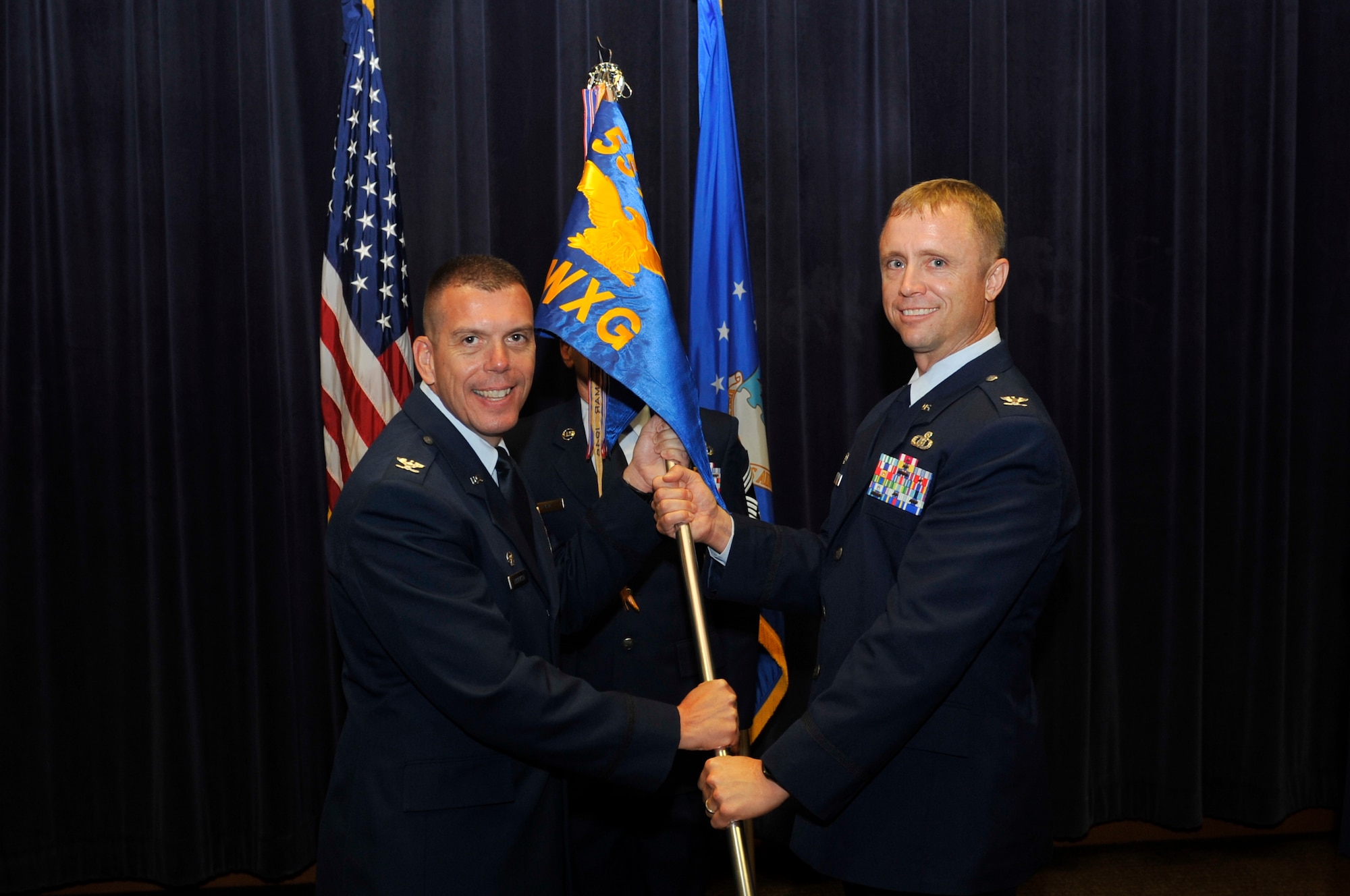 Col. Steven Dickerson, commander of the 557th Weather Wing, left, passes the guidon to Col. Jason Patla, the incoming commander of the 2nd Weather Group in the 557th WW Auditorium at Offutt Air Force Base, Neb., Aug. 1, 2016. Patla assumed command from Col. Steven Shannon, who served as commander for the last two years. (U.S. Air Force photo/Jeff Bridges)