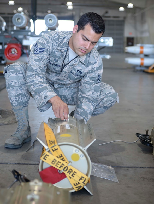 Staff Sgt. Anthony Anderson, a conventional maintenance crew chief and munitions inspector assigned to the 28th Munitions Squadron, works to connect a lanyard to a pin connected to the bomb tail at Ellsworth Air Force Base (AFB), S.D., July 20, 2016. Anderson said one of the many things that keeps him motivated is seeing his work pay off downrange and encourages Airmen to always have a positive attitude. (U.S. Air Force photo by Airman 1st Class Sadie Colbert)