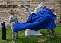 Col. Andrew Hansen, 51st Fighter Wing commander, and Chief Master Sgt. Alex Del Valle, 51st Fighter Wing command chief, unveil the new eagle statue dedicated to retired Master Sgt. Jim Price outside of the base enlisted club at Osan Air Base, Republic of Korea, Aug. 1, 2016. The previous eagle statue was damaged in the fall of 2015, and was replaced with a larger, more detailed statue thanks largely to the efforts and contributions of the Osan Chief’s Group, Team Osan Spouses Club, and the 731st Air Mobility Squadron. (U.S. Air Force photo by Senior Airman Victor J. Caputo/Released)