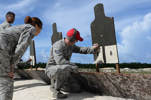 Staff Sgt. William Adkins, 36th Security Forces Squadron combat arms instructor, calculates the adjustments Airman 1st Class Mylia Simpson, 36th SFS entry controller, needs to make on her M4 carbine’s sights to be more accurate onJuly 7, 2016, at Andersen Air Force Base, Guam. The target is used to determine how sights need to be adjusted and consists of a four quadrant grid with a target in the center. If the shots fired all land in an area other than the target, the grid system indicates the variance and in which direction to adjust rear and front sights. (U.S. Air Force photo by Airman 1st Class Jacob Skovo)