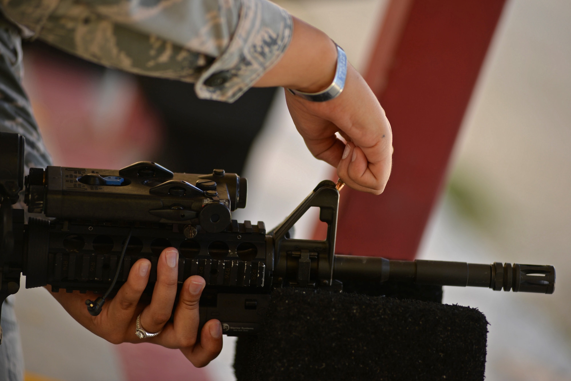 Airman 1st Class Mylia Simpson, 36th Security Forces Squadron entry controller, adjusts the front sight of her M4 carbine July 7, 2016, at Andersen Air Force Base, Guam. The target is used to determine how sights need to be adjusted and consists of a four quadrant grid with a target in the center. If the shots fired all land in an area other than the target, the grid system indicates the variance and in which direction to adjust rear and front sights. (U.S. Air Force photo by Airman 1st Class Jacob Skovo)