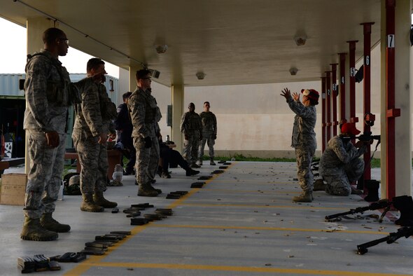 Staff Sgt. Lolita Aguon and Senior Airman William Brown, 36th Security Forces Squadron combat arms instructors, demonstrate firing techniques July 7, 2016, at Andersen Air Force Base, Guam. Weapons qualification is often done in preparation for deployments, for certain permanent changes of station and annually for certain career fields. (U.S. Air Force photo by Airman 1st Class Jacob Skovo)