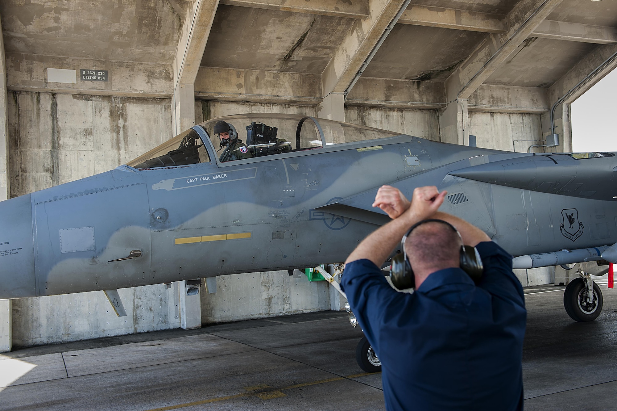 U.S. Air Force Staff Sgt. Michael Hilborn, 44th Aircraft Maintenance Unit crew chief, marshals in a 44th Fighter Squadron F-15 Eagle after returning from an exercise, Aug. 2, 2016, at Kadena Air Base, Japan. The 44th FS participated in Cope Taufan, a training exercise in Malaysia to build strategic partnerships with foreign militaries. (U.S. Air Force photo by Airman 1st Class Corey M. Pettis)