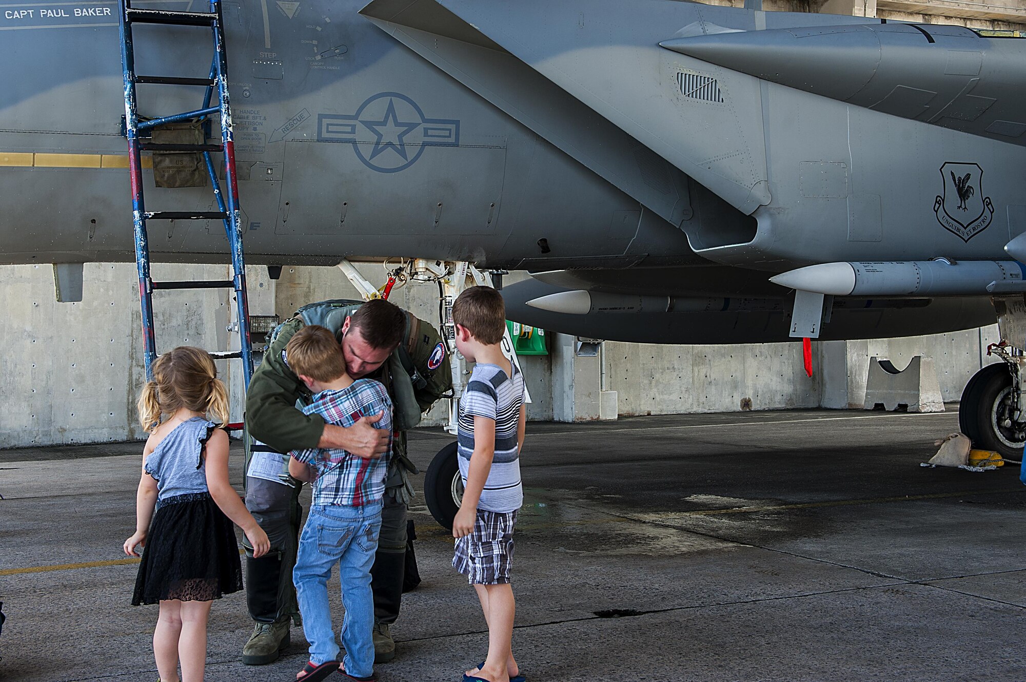 Capt. Tyson Hyer, 44th Fighter Squadron pilot, is greeted by his children after returning from an exercise, Aug. 2, 2016, at Kadena Air Base, Japan. The 44th FS returned from Exercise Cope Taufan, an exercise between the U.S. Air Force and the Royal Malaysian Air Force to train together on air combat tactics. (U.S. Air Force photo by Airman 1st Class Corey M. Pettis)