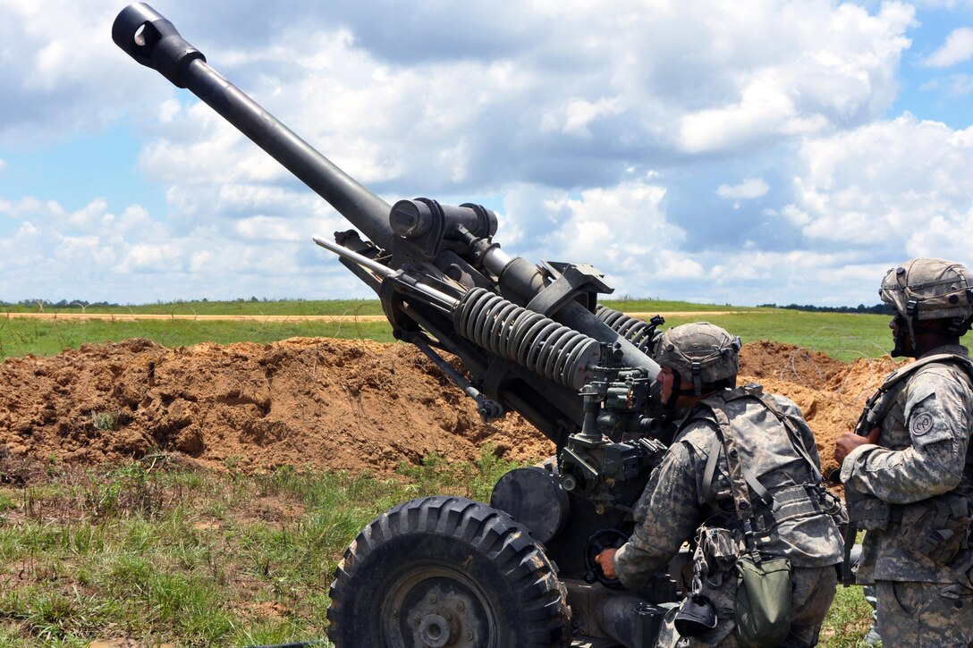 Army Sgt. Erik Paredes looks through the site of a M119 Howitzer and Army Staff Sgt. Geriff Polanco observes during live-fire training at Fort Polk, La., July 26, 2016. Paredes and Polanco are assigned to the New York Army National Guard’s 1st Battalion, 258th Field Artillery. Army National Guard photo by Sgt. Maj. Corine Lombardo