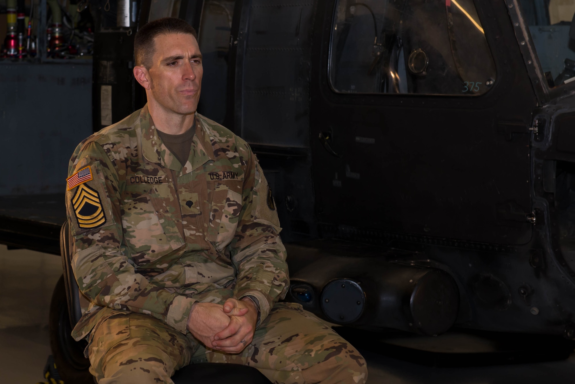 U.S. Army Spc. Daryn Colledge, 168th Aviation Regiment UH-60 Blackhawk Helicopter repair student, sits next to a retired Special Forces Blackhawk at Fort Eustis, Va., July 28, 2016. Colledge retired from the National Football League after nine seasons and a Super Bowl Championship, and enlisted in the Army National Guard in March 2016 out of Idaho. (U.S. Air Force photo by Airman 1st Class Derek Seifert)