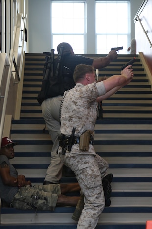 A team of police officers from the Marine Corps Base Quantico Provost Marshal Office head to the second floor of Crossroads Elementary School to search for an active shooter during a drill held July 27.