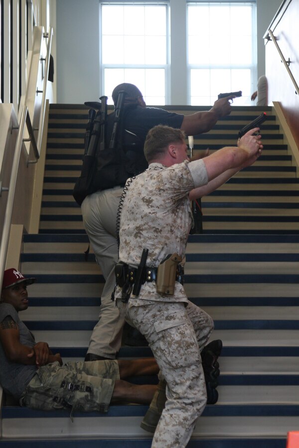A team of police officers from the Marine Corps Base Quantico Provost Marshal Office head to the second floor of Crossroads Elementary School to search for an active shooter during a drill held July 27.