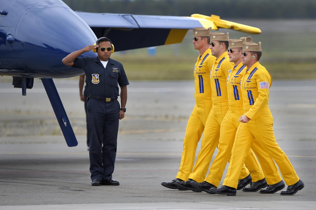 A Navy crew chief salutes as pilots with the Blue Angels, the Navy's flight demonstration team, proceed to their F/A-18 Hornet aircraft for an aerial performance during the Arctic Thunder Open House at Joint Base Elmendorf-Richardson, Alaska, July 31, 2016. Air Force photo by Alejandro Pena