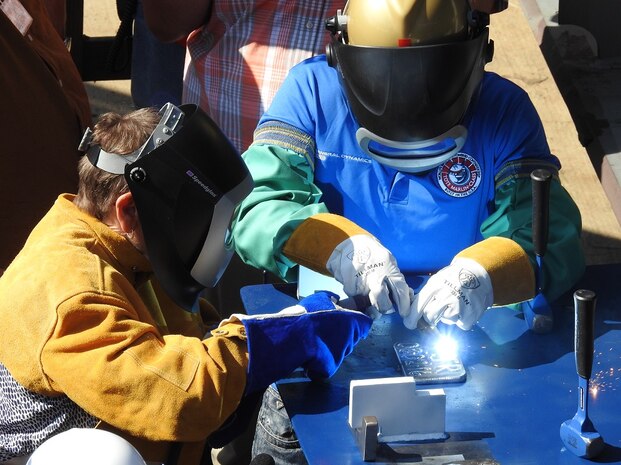 SAN DIEGO, Calif (Aug. 2, 2016) Ms. Travie Ross, daughter of Hershel Woodrow "Woody" Williams, welds her initials into the ship's keel during a keel laying ceremony for the future USNS Hershel "Woody" Williams (ESB 4) in San Diego, California, Aug 2. Hershel Woodrow "Woody" Williams is the last living Medal of Honor recipient from the Battle of Iwo Jima. PEO Ships is responsible for executing the development and procurement of all destroyers, amphibious ships, special mission and support ships, boats and craft.