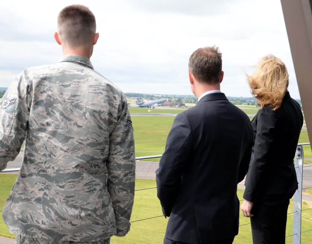 U.S. Air Force Airman 1st Class Sheldon Jones, left, 100th Operations Support Squadron air traffic controller, shows Amanda Simpson, right, Deputy Assistant Secretary of Defense for Operational Energy, and Robert Warshel, center, Director of Operations, Operational Energy Plans and Programs, the view from the Air Traffic Control Tower as a KC-135 Stratotanker departs July 29, 2016, on RAF Mildenhall, England. Simpson and Warshel visited many areas of base including the 100th Logistics Readiness Squadron Fuels flight, the 100th Force Support Squadron Dining Facility, the 100th Maintenance Squadron and the 100th Civil Engineer Squadron. (U.S. Air Force photo by Gina Randall)
