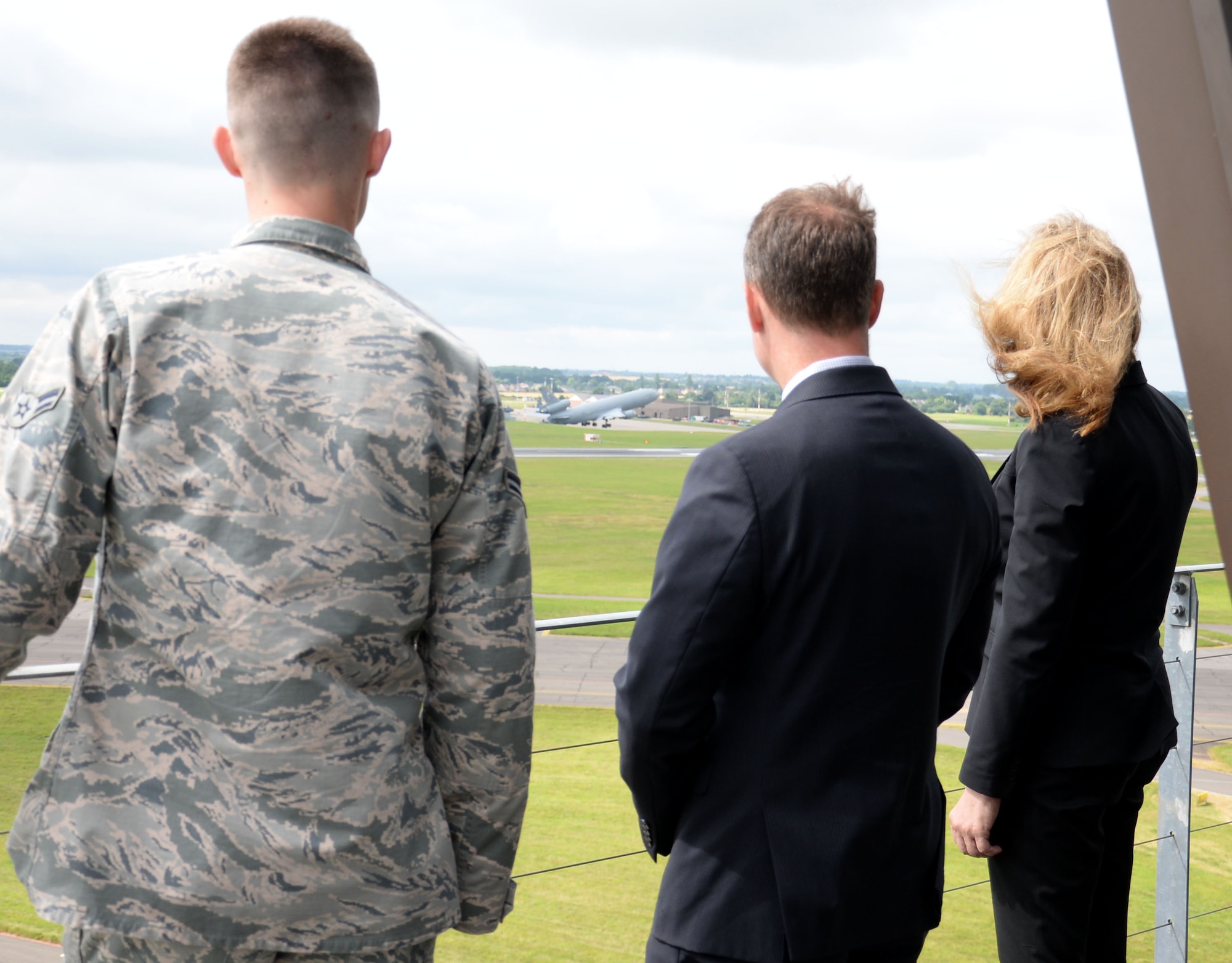 U.S. Air Force Airman 1st Class Sheldon Jones, left, 100th Operations Support Squadron air traffic controller, shows Amanda Simpson, right, Deputy Assistant Secretary of Defense for Operational Energy, and Robert Warshel, center, Director of Operations, Operational Energy Plans and Programs, the view from the Air Traffic Control Tower as a KC-135 Stratotanker departs July 29, 2016, on RAF Mildenhall, England. Simpson and Warshel visited many areas of base including the 100th Logistics Readiness Squadron Fuels flight, the 100th Force Support Squadron Dining Facility, the 100th Maintenance Squadron and the 100th Civil Engineer Squadron. (U.S. Air Force photo by Gina Randall)