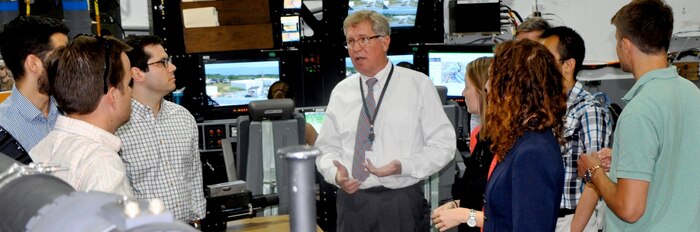 DAHLGREN, Va. - Ralph Stewart, Naval Surface Warfare Center Dahlgren Division (NSWCDD) Battle Management System Program Manager, briefs congressional staffers during the delegation's tour of the NSWCDD Battle Management System and Laboratory, July 29. The staffers - representing congressmen and women from Rhode Island, California, Alabama, Virginia, Hawaii, Indiana and Oklahoma - also received tours and briefings on the electromagnetic railgun, directed energy, virtualization, cybersecurity, and combined integrated air and missile defense-antisubmarine warfare. NSWCDD is a premier research and development center that serves as a specialty site for weapon system integration. The command's unique ability to rapidly introduce new technology into complex warfighting systems is based on its longstanding competencies in science and technology, research and development, and test and evaluation.