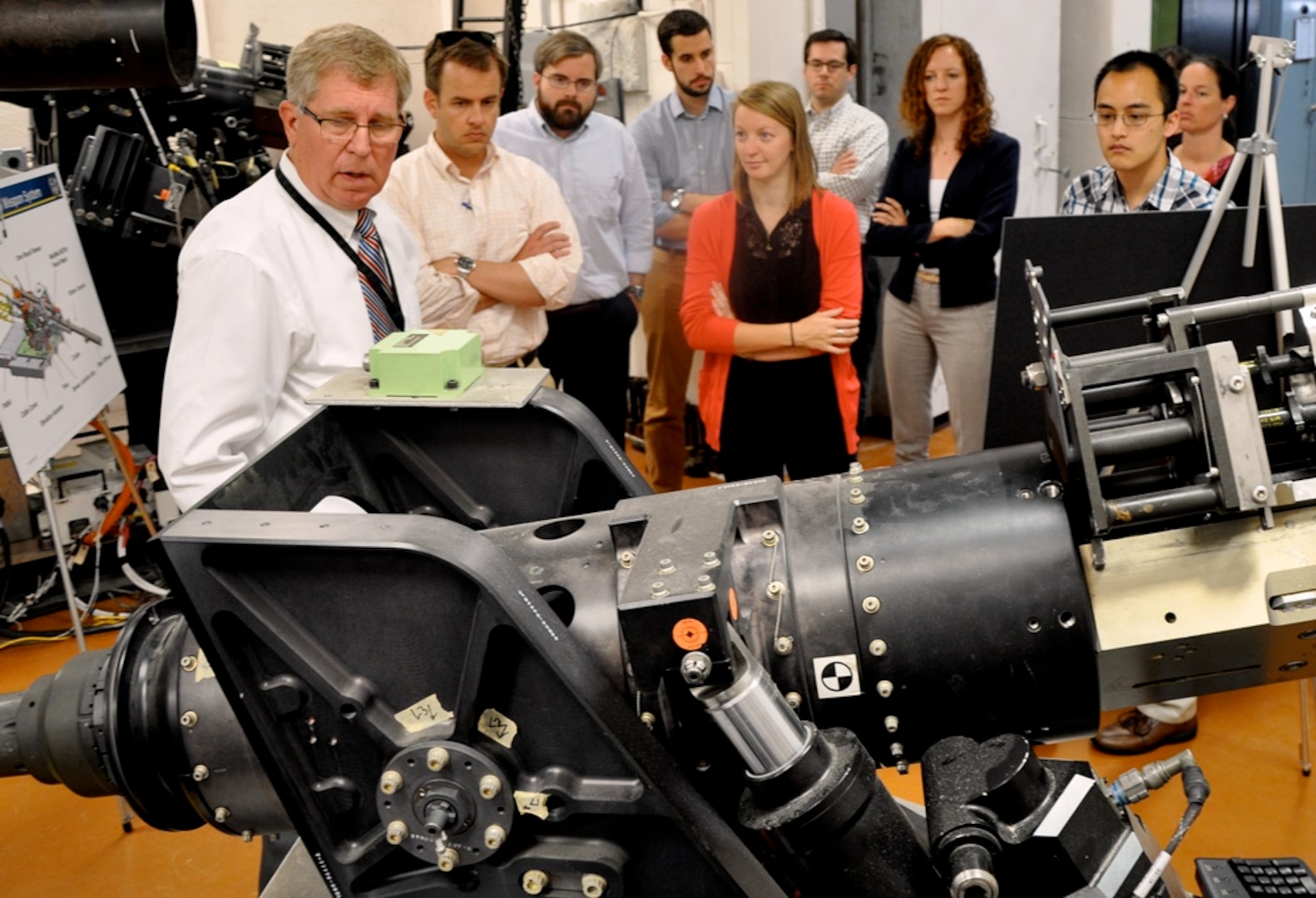 DAHLGREN, Va. - Naval Surface Warfare Center Dahlgren Division (NSWCDD) senior engineer Ralph Stewart briefs congressional staffers on the 105 MM gun weapon system during the delegation's tour of the NSWCDD Battle Management System and Laboratory, July 29. The staffers - representing congressmen and women from Rhode Island, California, Alabama, Virginia, Hawaii, Indiana and Oklahoma - also received tours and briefings on the electromagnetic railgun, directed energy, virtualization, cybersecurity, and combined integrated air and missile defense-antisubmarine warfare. NSWCDD is a premier research and development center that serves as a specialty site for weapon system integration. The command's unique ability to rapidly introduce new technology into complex warfighting systems is based on its longstanding competencies in science and technology, research and development, and test and evaluation.