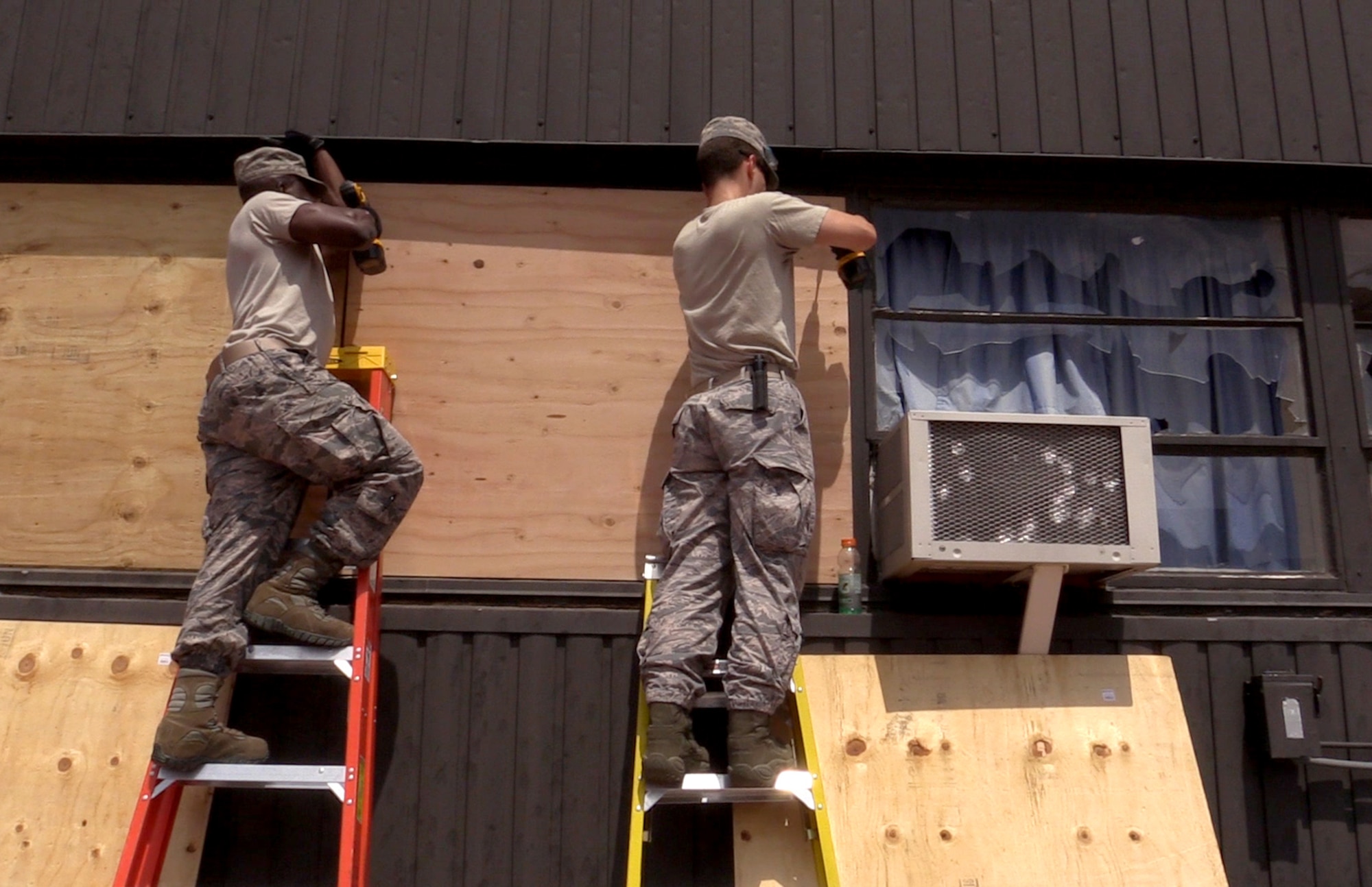 Airmen assigned to the 21st Civil Engineer Squadron board broken windows at Peterson Air Force Base, Colo., Aug. 1, 2016. Peterson AFB was hit by a storm carrying hail the size of baseballs. (U.S. Air Force photo by Technical Sgt. Joshua Arends)