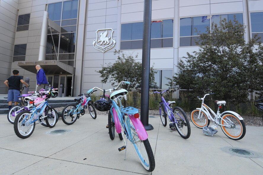 Children’s bicycles line the front of Building 210 at Schriever Air Force Base, Colorado, before the Amazing gRace: Kids Edition Saturday, July 30, 2016. Competitors were required to ride bicycles during the scavenger hunt to reach the stations scattered throughout the base. (U.S. Air Force photo/2nd Lt. Darren Domingo)