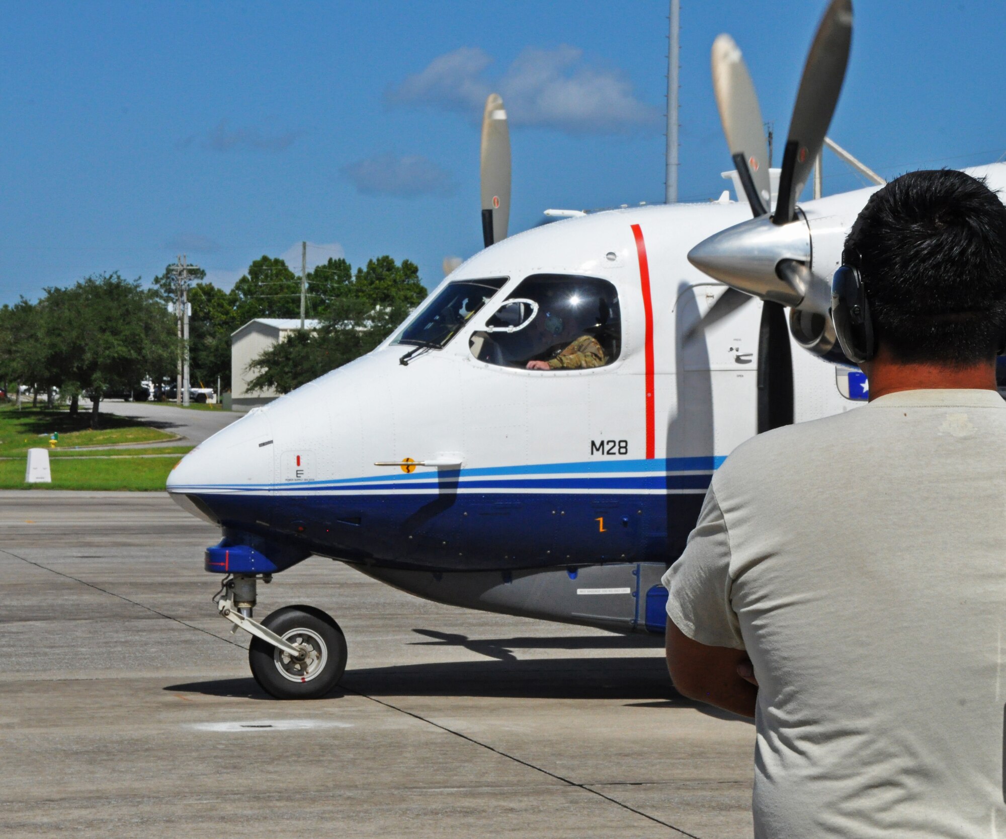 A maintenance crew chief watches as a C-145A Skytruck piloted by Maj. Gen. Eugene Haase, Air Force Special Operations Command vice commander, prepares to taxi on the Duke Field, Fla., flightline July 28, 2016.  Haase spent the day getting a close-up look at how Duke's Reserve and active-duty Airmen work seamlessly under the Total Force Integration concept to perform their shared AFSOC mission sets.  (U.S. Air Force photo/Dan Neely)