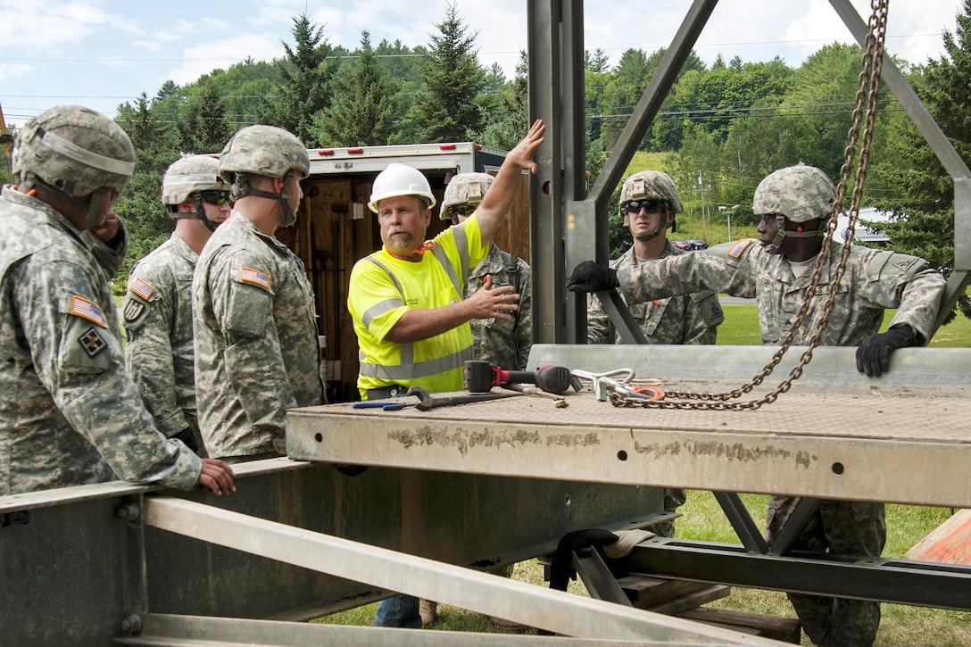 Hobie Gates, center, a special project supervisor for the Vermont Agency of Transportation bridge crew, instructs Connecticut Army National Guardsmen on the assembly of a Mabey Logistic Support Bridge as part of a simulated bridge collapse during the Vigilant Guard 2016 training exercise in Berlin, Vt., July 29, 2016.  Air National Guard photo by Tech. Sgt. Chelsea Clark