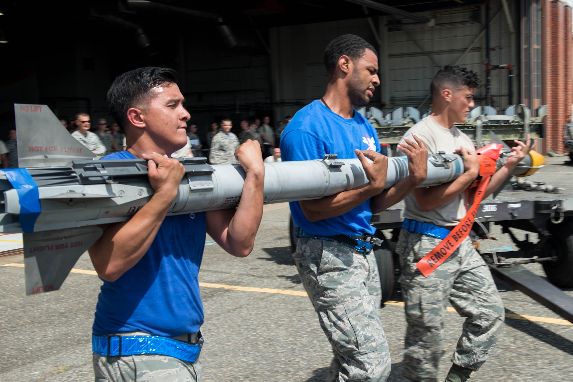 U.S. Air Force Airmen from the 94th Aircraft maintenance unit carry an AIM-9 missile to an F-22 Raptor during the 1st Maintenance Squadron Weapons Load Crew of the Quarter competition at Langley Air Force Base, Va., July 29, 2016. During the weapons-load portion of the competition, each team was tasked to load an AIM-9M, 
AIM-9X and a GBU-32 Joint Direct Attack Munition using a manually operated lift truck as quickly and accurately as possible. (U.S. Air Force photo by Staff Sgt. R. Alex Durbin)