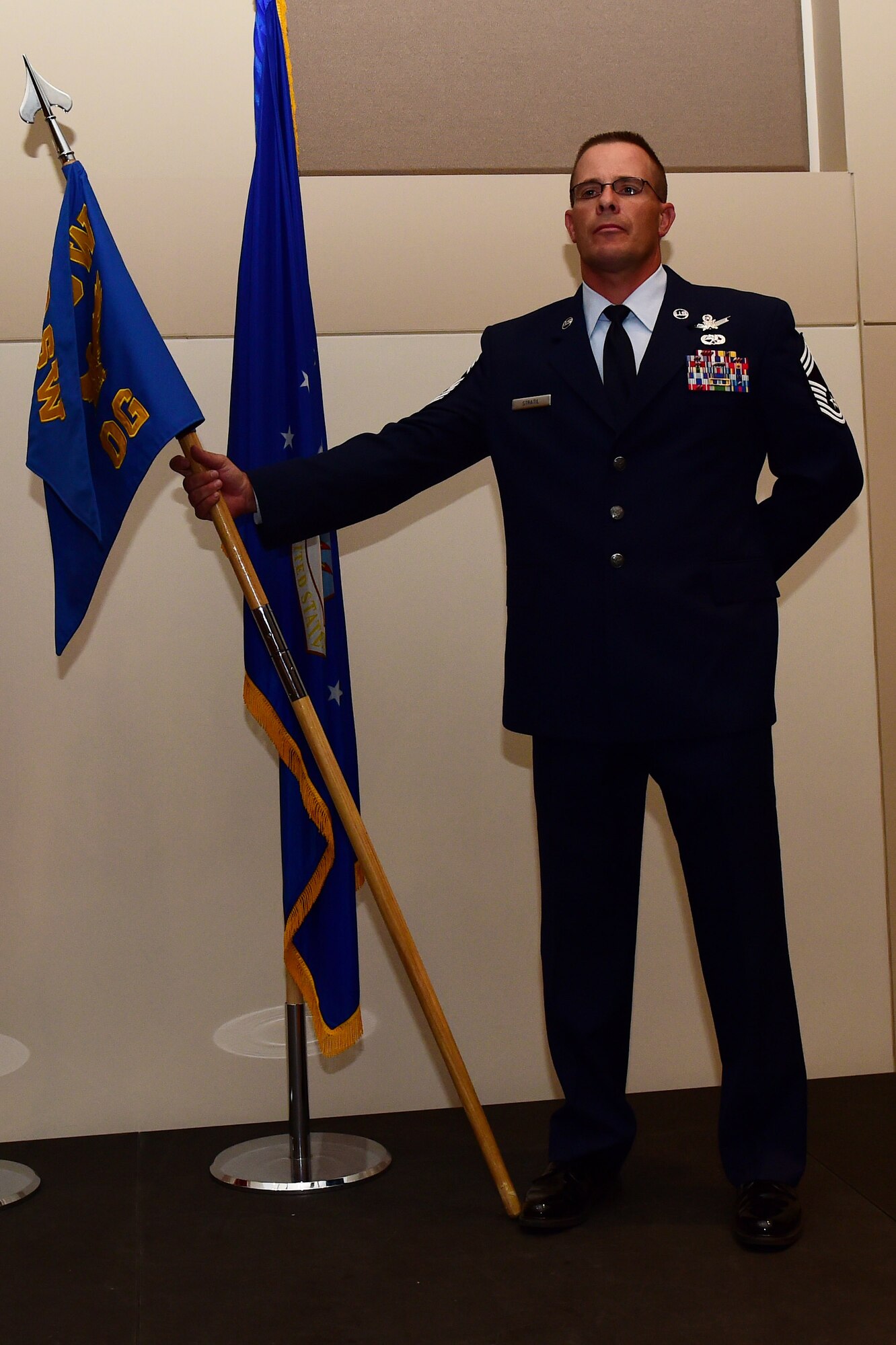 Chief Master Sgt. Joseph Stratil, 460th Operations Group superintendent, guards the OG guidon August 2, 2016, during the OG assumption of command ceremony at the Leadership Development Center on Buckley Air Force Base, Colo. The guidon is exchanged during the ceremony as a symbol providing a view of the command authority being transferred from one commander to the next. (U.S. Air Force photo by Airman 1st Class Gabrielle Spradling/Released)
