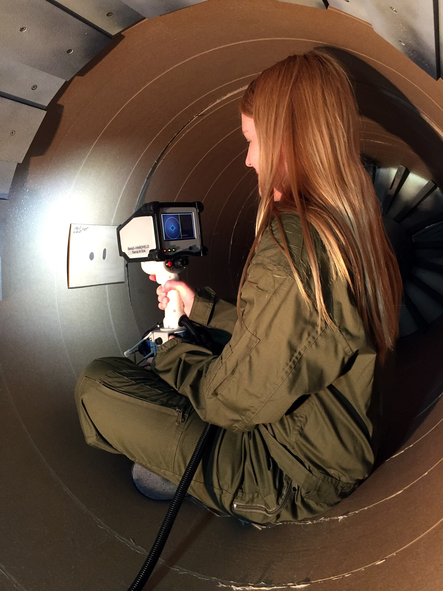 An aircraft maintainer demonstrates the Auto-Scan: Inlet and Exhaust Damage Registration Sensor.  This tool, developed through an AFRL Critical Small Business Innovative Research contract with Intelligent Automation, Inc., provides a faster and easier way to characterize inlet and exhaust damage in high-performance aircraft. (Photo courtesy of Intelligent Automation, Inc.)