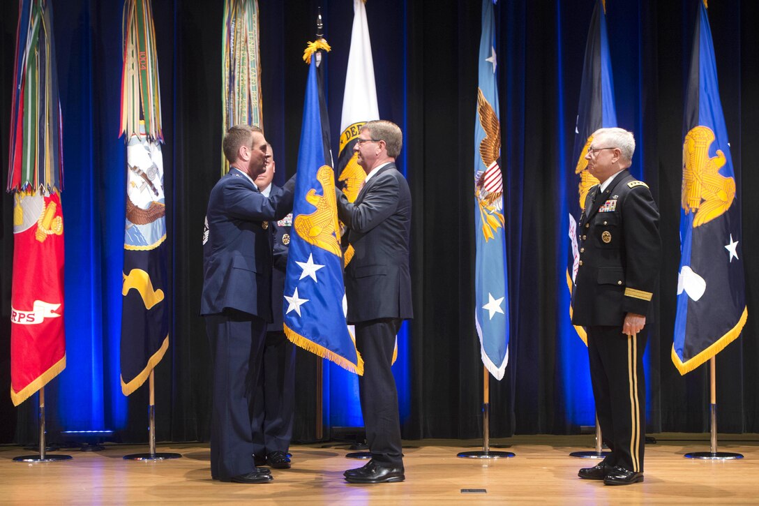 Defense Secretary Ash Carter hands the command colors to Air Force Gen. Joseph L. Lengyel during a National Guard Bureau change-of-responsibility ceremony at the Pentagon, Aug. 3, 2016. Lengyel took over as chief of the bureau during the ceremony, succeeding Army Gen. Frank Grass, right. DoD photo by Navy Petty Officer 1st Class Tim D. Godbee