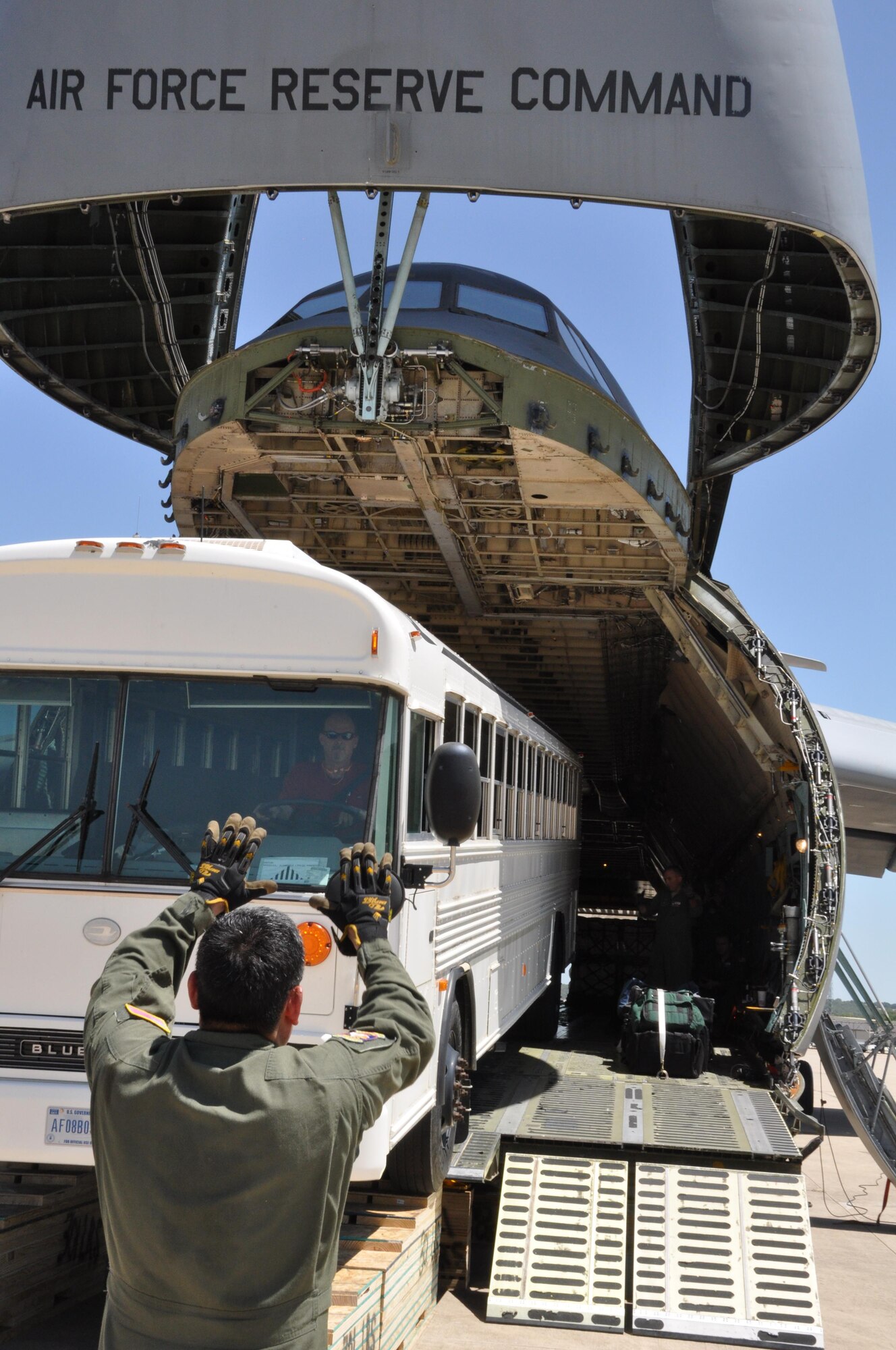 Staff Sgt. Cody Holsey, an Air Force Reserve C-5 loadmaster assigned to the 68th Airlift Squadron, positions a pedestal shore under the aircraft before loading a 45-passenger bus here Aug. 2. Members of the 301st Logistics
Readiness Squadron designed and created pedestal and approach shoring to safely load this bus without damaging the aircraft or vehicle. (U.S. Air Force photo by Capt. Candice Allen) 
