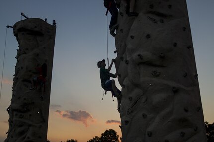 A child climbs a rock wall during the 33rd annual National Night Out at the McGlachlin Parade Field on Fort Meade, Md., Aug. 2. National Night Out is an annual community-building campaign that promotes partnerships with first-responder agencies to make neighborhoods safer and better places to live. The event was established in 1984 and participation has increased from 2.5 million people in 400 communities to more than 32 million people in 9,530 communities since. Soldiers from the 200th Military Police Command had a static display with military vehicles, weapons and protective equipment. (U.S. Army Reserve photo by Spc. Stephanie Ramirez)