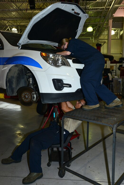 U.S. Air Force Airman 1st Class Taylor Elcook, 633rd Logistics Readiness Squadron vehicle maintenance apprentice, and U.S. Air Force Staff Sgt. Nina Rack, 633rd LRS vehicle maintenance supervisor, replace the engine wiring harness in a security forces vehicle at Langley Air Force Base, Va., Aug. 2, 2016. The vehicle maintenance shop performs repairs and routine checks on 30 vehicles each week. (U.S. Air Force photo by Airman 1st Class Tristan Biese)