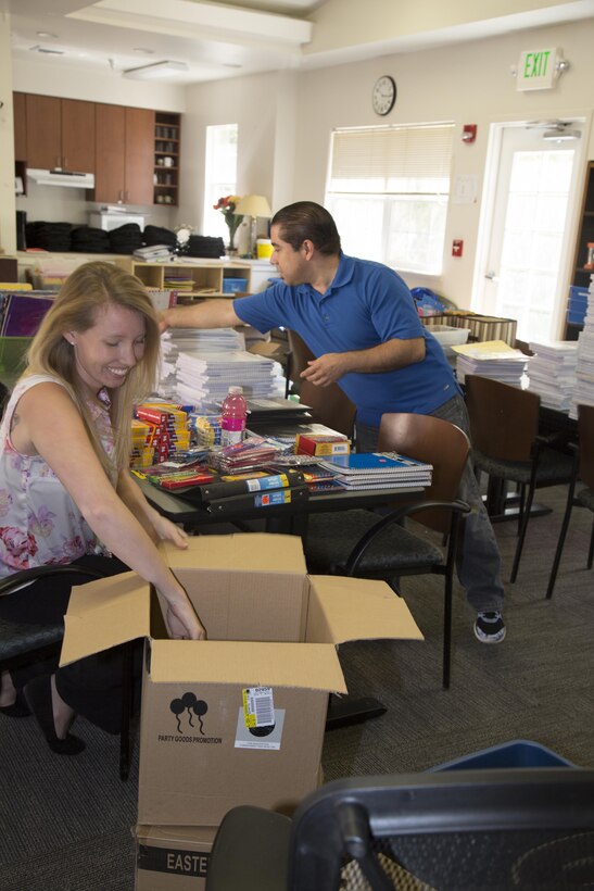 Ashley Ignatz, trainer with Marine Corps Family Team Building and Adam Diaz, Exceptional Family Member Program case worker and School Liaison Program officer sort, count and ready supplies for the Back to School Brigade held aboard Marine Corps Logistics Base Barstow, Calif., July 26. The annual event, held on July 27, offers backpacks and school supplies to military families. 