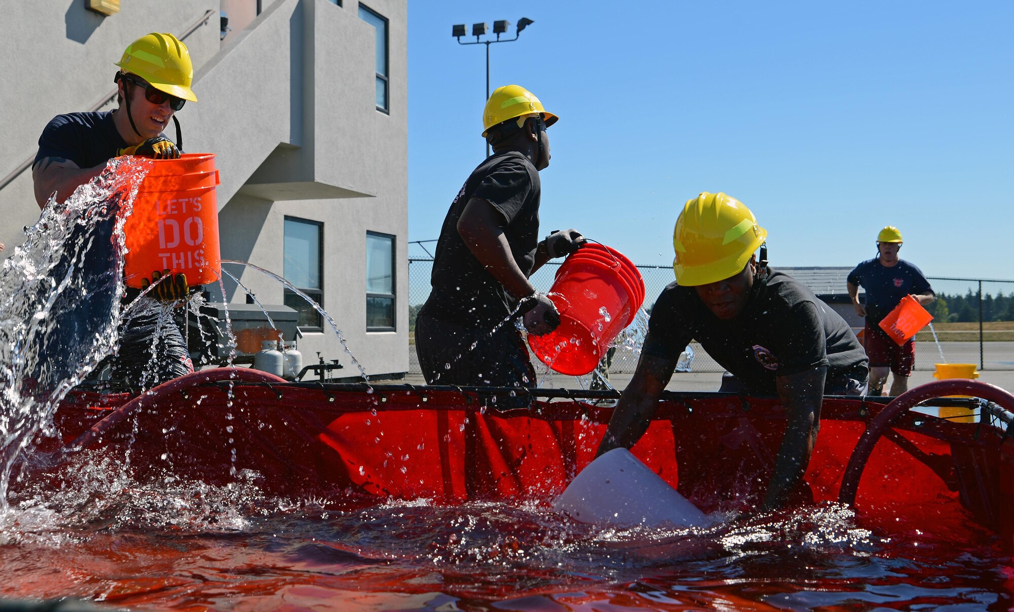 Firefighters from Fire Station 105 on McChord Field, participate in a bucket brigade July 26, 2016, during a firefighter combat challenge at Joint Base Lewis-McChord, Wash. The bucket brigade was one of nine different events in the timed fire fighter combat challenge. (U.S. Air Force photo/Senior Airman Jacob Jimenez) 