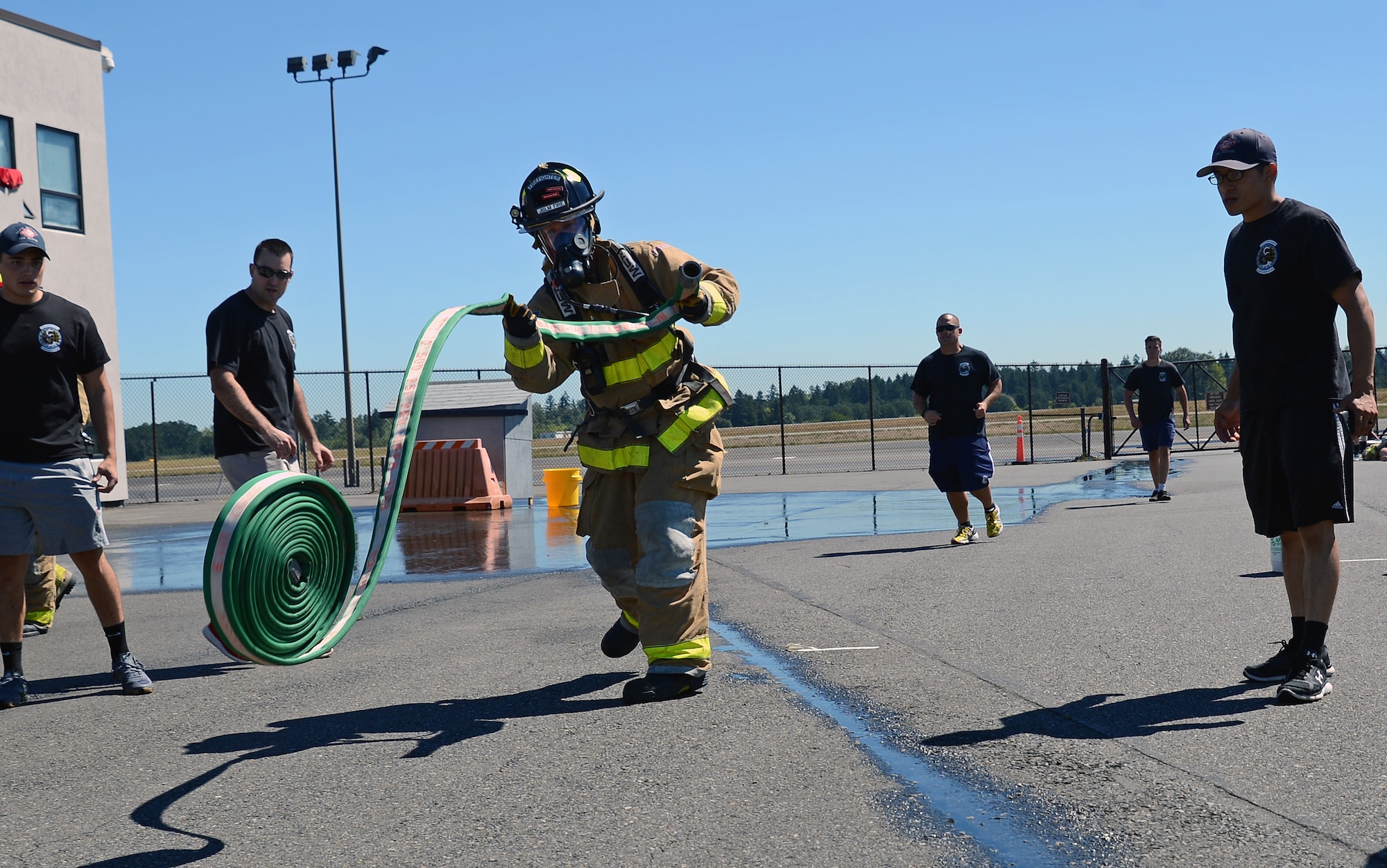 A firefighter from Fire Station 105 on McChord Field, throws a firehose July 26, 2016, during the firefighter combat challenge at Joint Base Lewis-McChord, Wash. The event was held to commemorate the legacy of Air Force firefighters who have served at JBLM. (U.S. Air Force photo/Senior Airman Jacob Jimenez) 