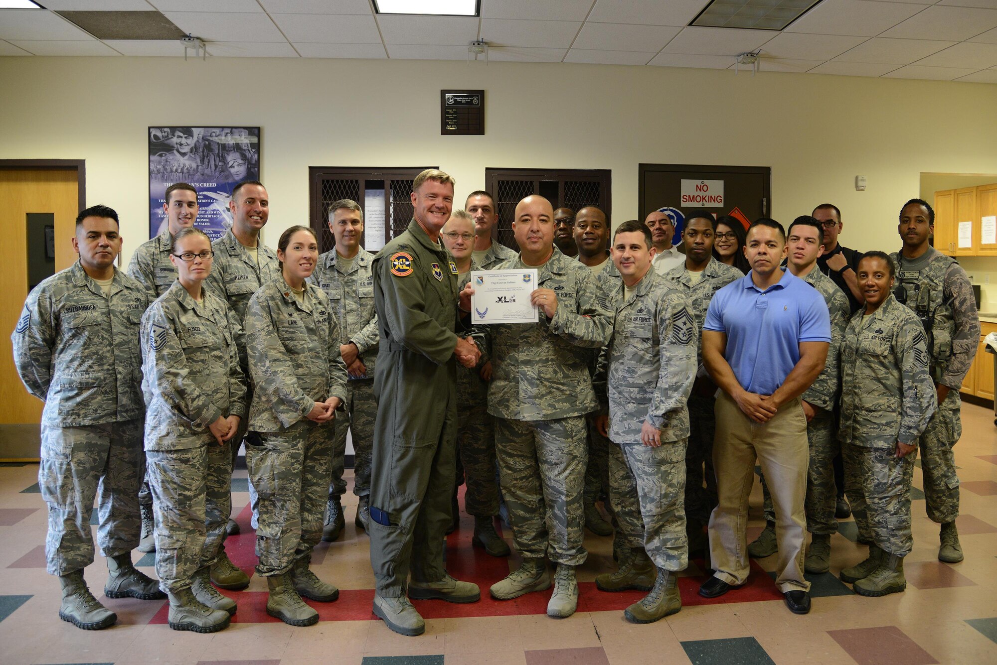 Technical Sgt. Estevan Salinas, front center, 47th Security Forces Squadron police and vehicle services non-commissioned officer, accepts the “XLer of the Week” award from Col. Thomas Shank, front left, 47th Flying Training Wing commander, and Chief Master Sgt. George Richey, front right, 47th FTW command chief here, July 27, 2016. The XLer is a weekly award chosen by wing leadership and is presented to those who consistently make outstanding contributions to their unit and Laughlin. (U.S. Air Force photo/Senior Airman Ariel D. Partlow)